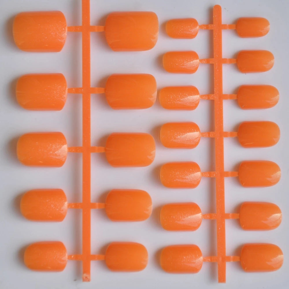 Set of orange plastic nails on a grid with a white background