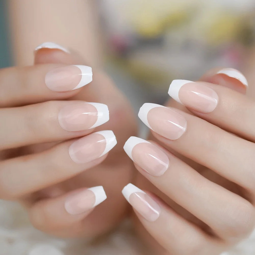 Close-up of hands with French manicure on a blurred background