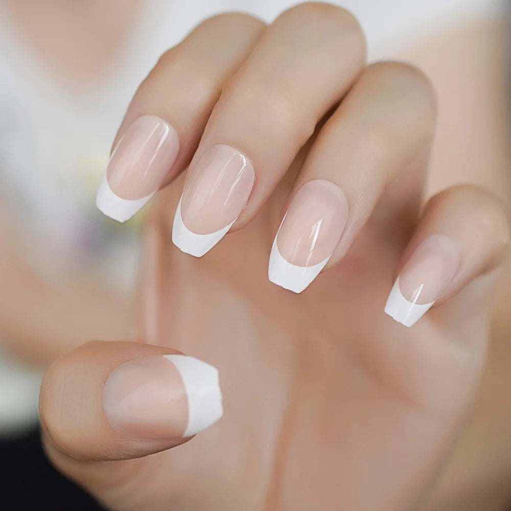 Close-up of a hand with nails painted in a French manicure style.