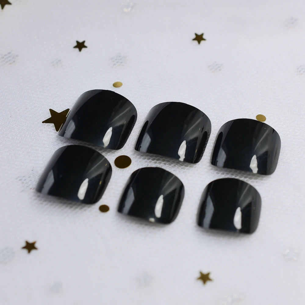 Set of six black nail caps on a white background with gold stars.