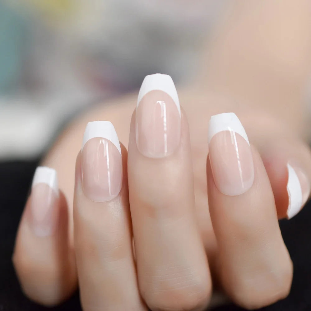 Close-up of a hand with nails painted in a French manicure style.