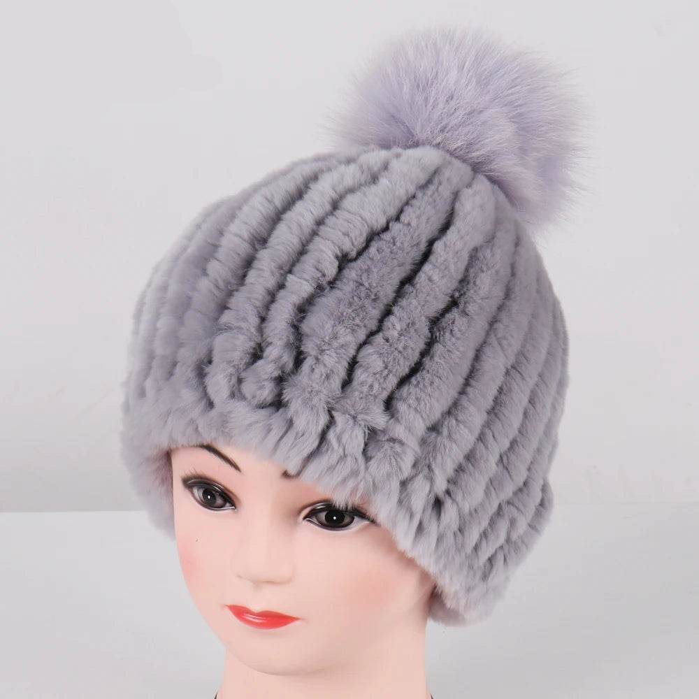 The hat laid flat, highlighting its knit pattern and the size of the pom-pom.