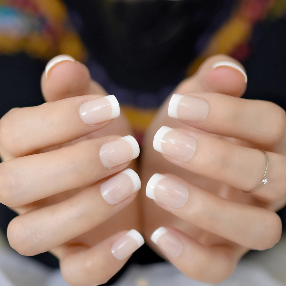 Close-up of hands with neatly manicured nails showing a neutral color.