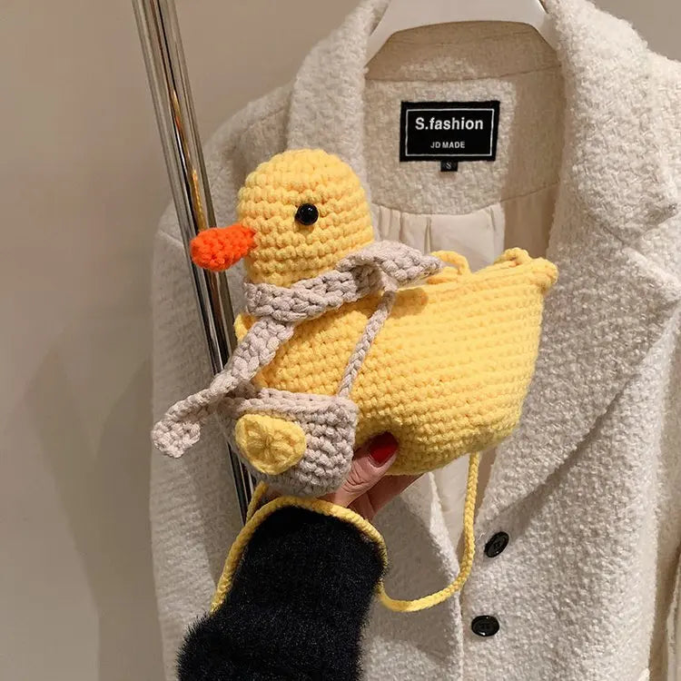 A close-up of the knitted duck-shaped crossbody bag, highlighting its texture and adorable duck features.

