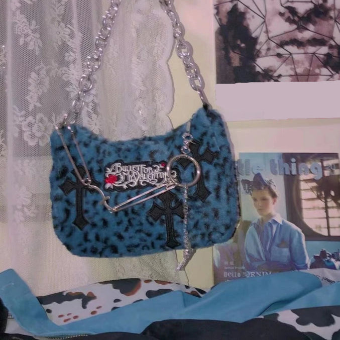 A close-up of the Gothic crossbody bag, highlighting its plush texture, chain strap, and edgy details.
