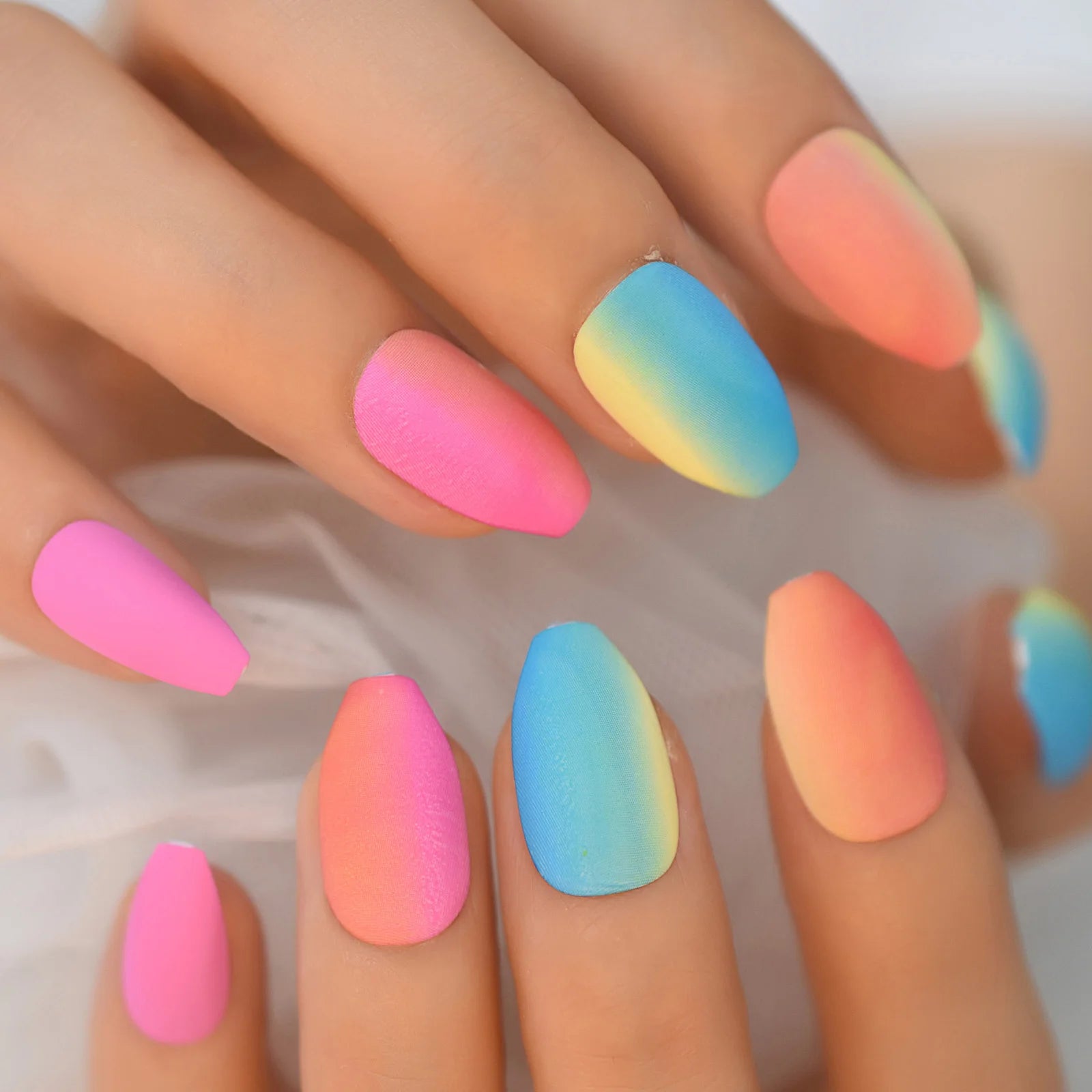 Colorful gradient nails on a hand with a blurred background