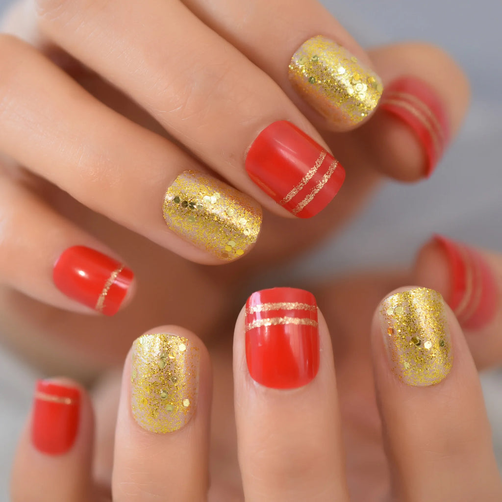 Close-up of hands with red and gold glitter nail polish