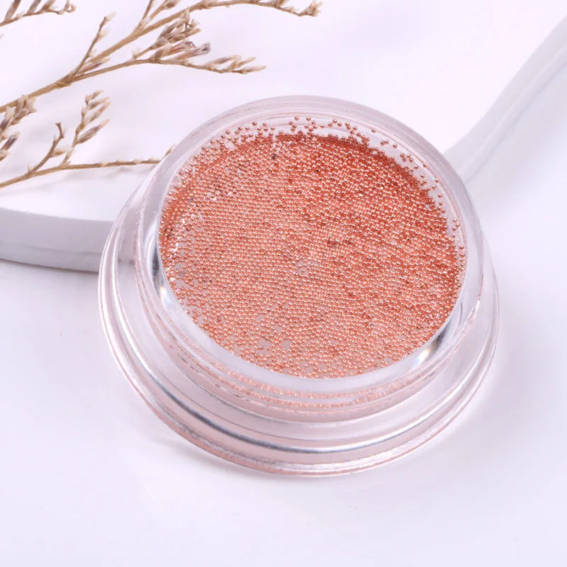 Rose gold glitter in a clear container on a white background with decorative elements.
