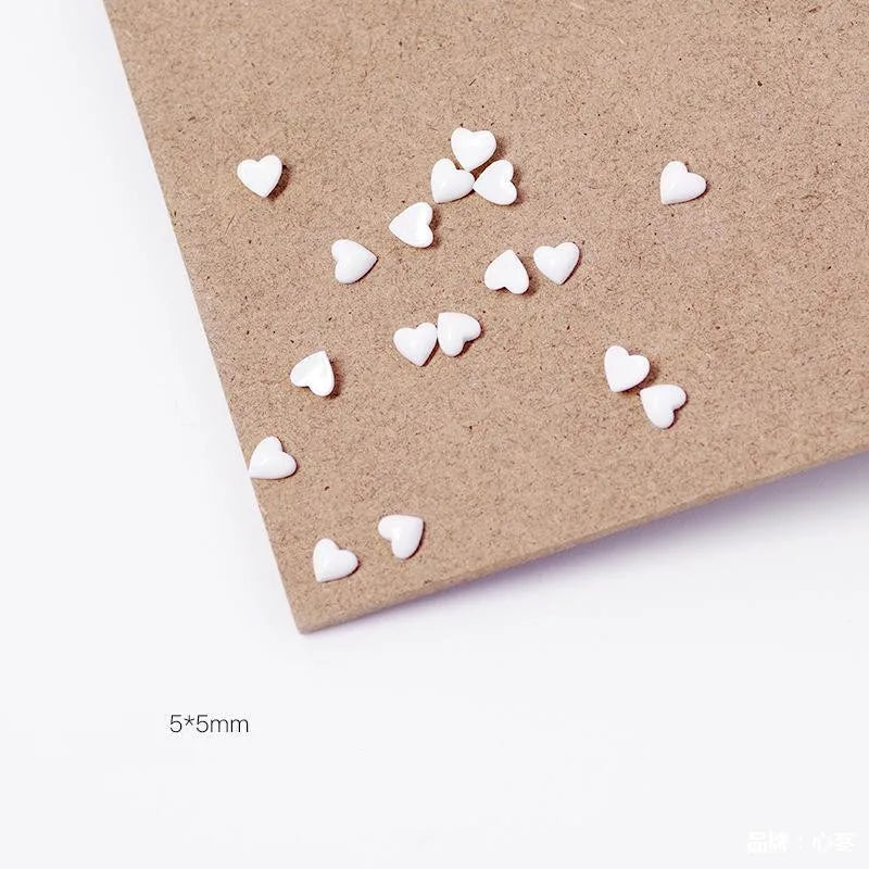 Small white heart-shaped objects on a brown paper background