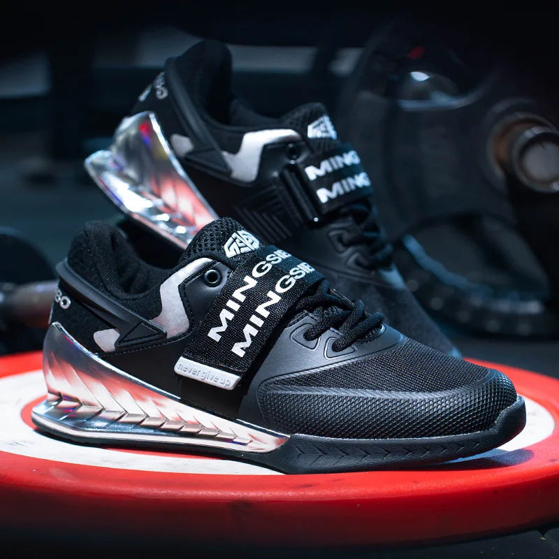 Black athletic shoes with branding on a red and black circular platform.