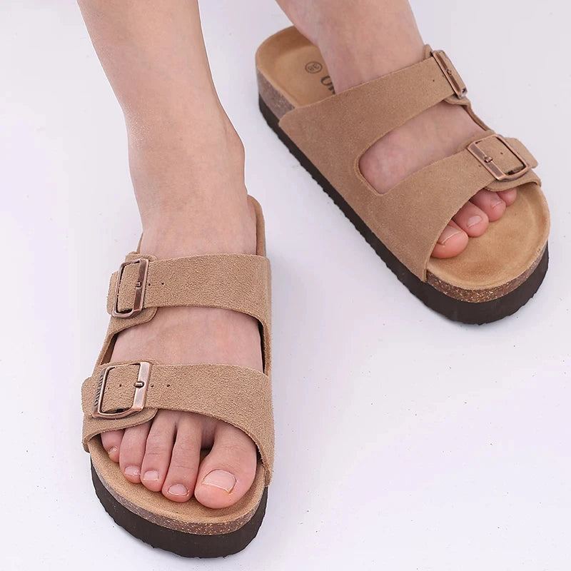 Open-toe cork slippers on beach background

