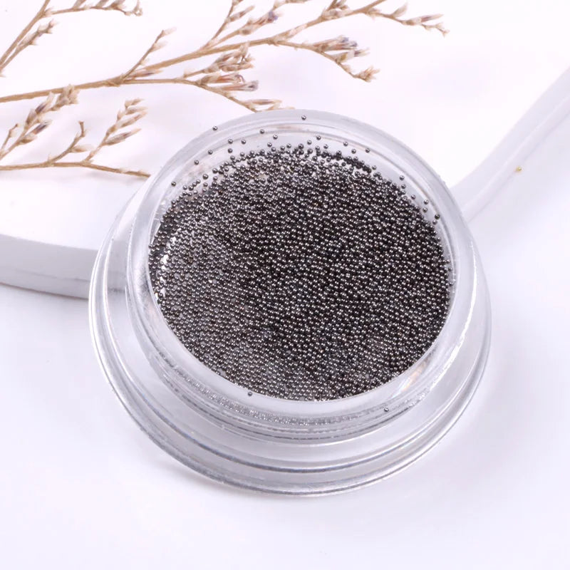Small container of black caviar on a white background with dried branches.