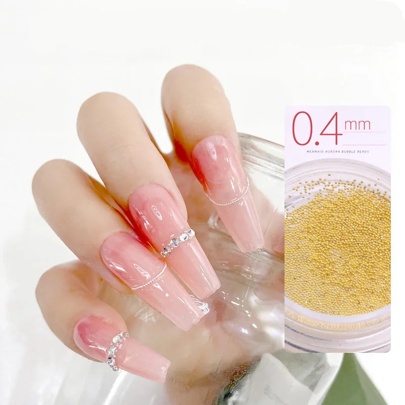 Hand with pink nails and decorative elements, showing 'Nail Steel Balls' product.