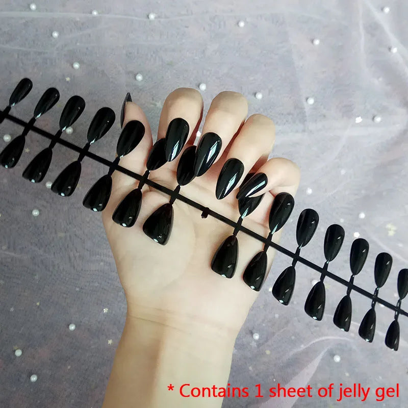 Nail extensions with black gel on a hand against a gray background