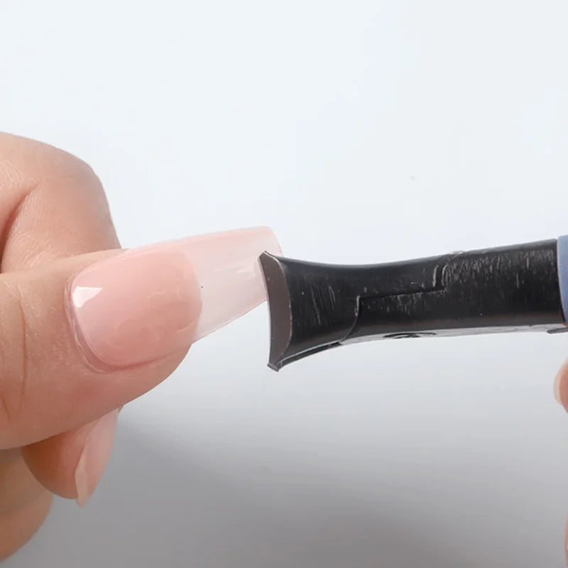 Hand holding a black and white pen against a light gray background