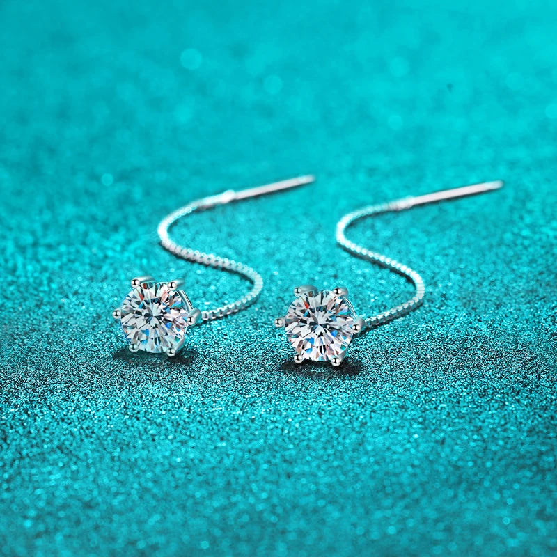 Close-up of one earring, highlighting the moissanite stone and tassel.

