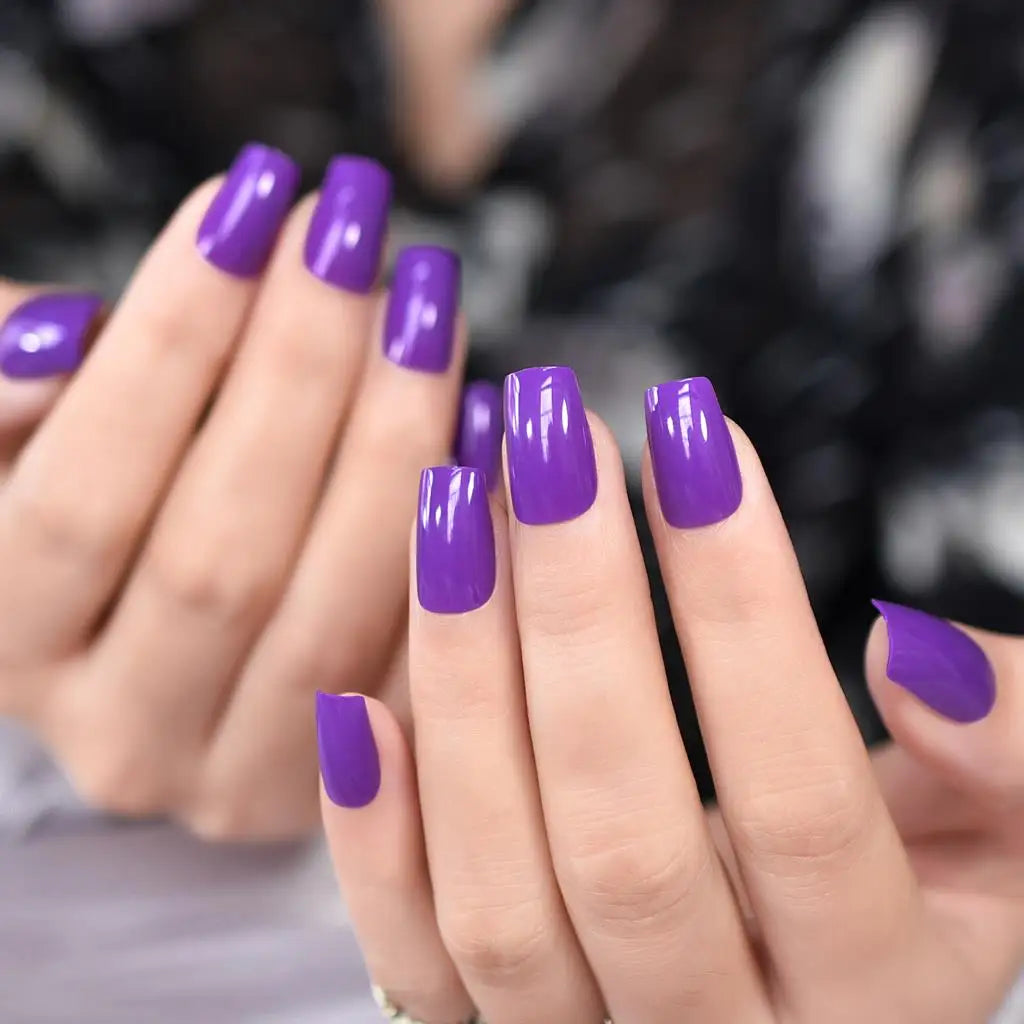 Close-up of hands with purple nail polish against a blurred background