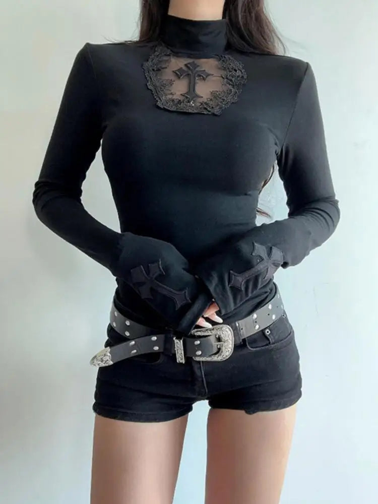 Person wearing a black turtleneck with decorative elements, black gloves, and denim shorts with a belt.