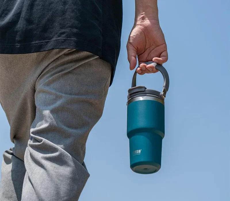 The travel mug placed in a car cup holder.