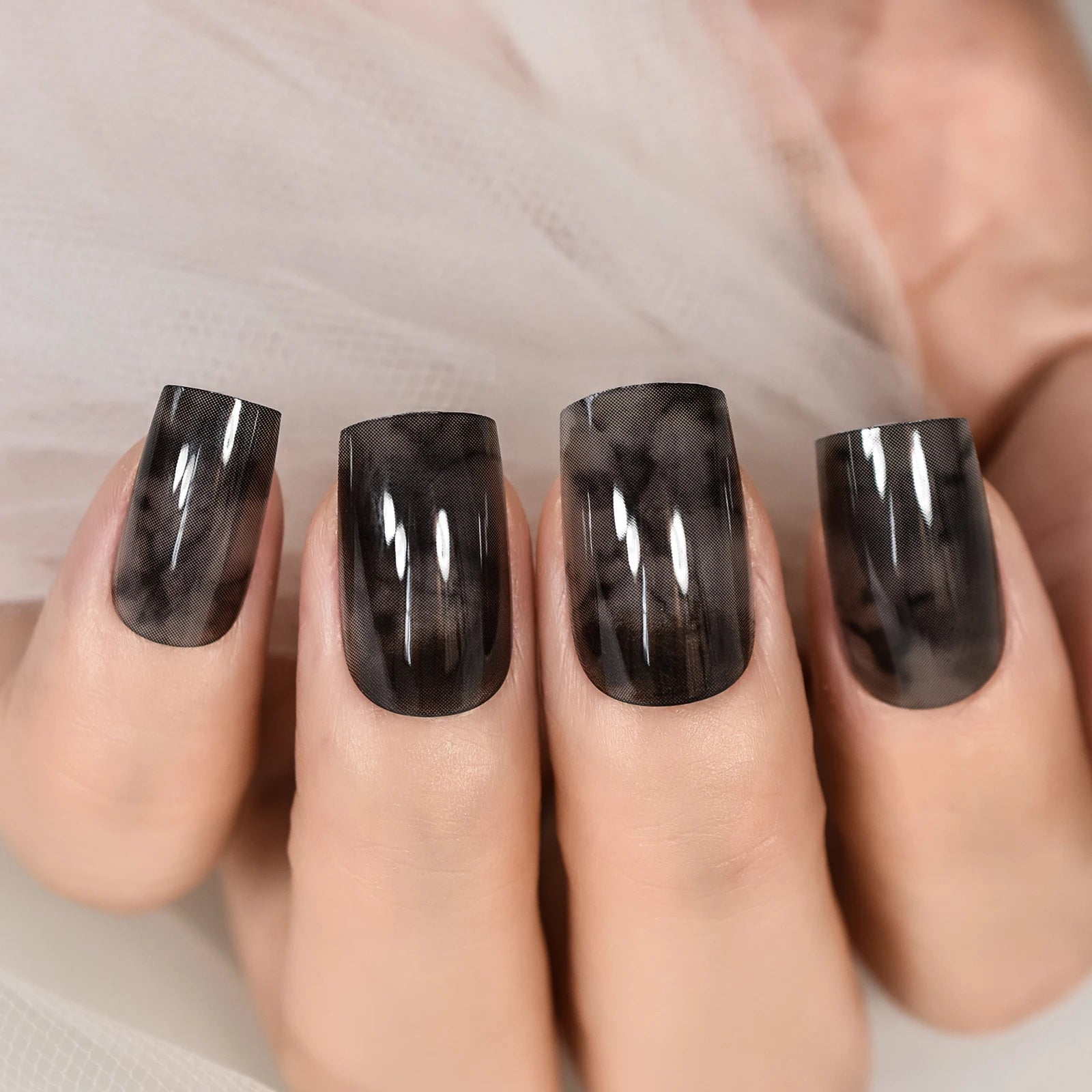 Close-up of a hand with dark nail polish on a neutral background