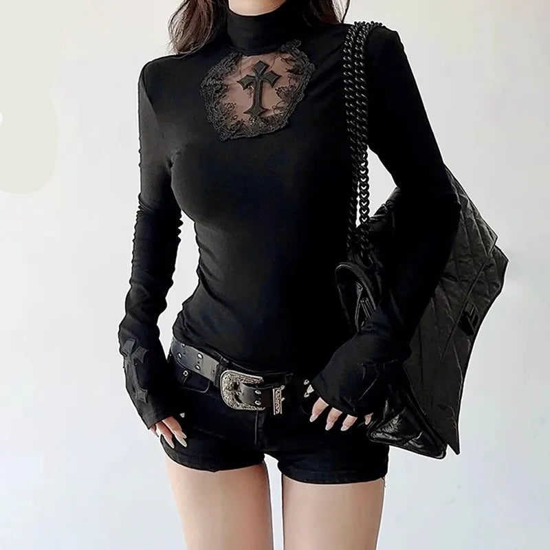 Person wearing a black long-sleeve top with lace detail and black shorts on a white background