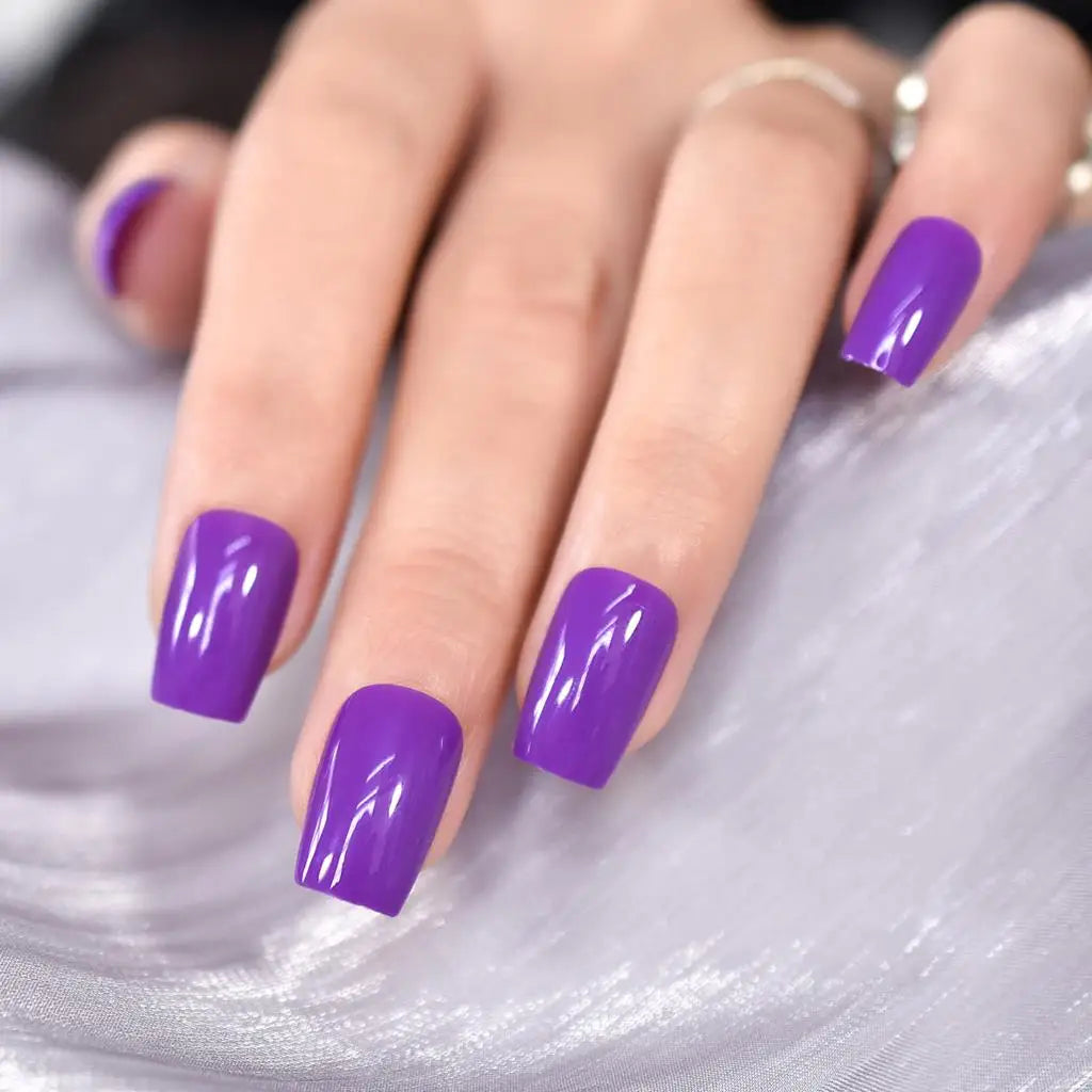Close-up of a hand with purple nail polish on a light gray background